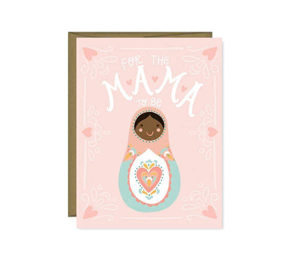 A pink baby shower greeting card with an cartoon image of a baby Russian nesting doll and the words 'For the Mama to Be'