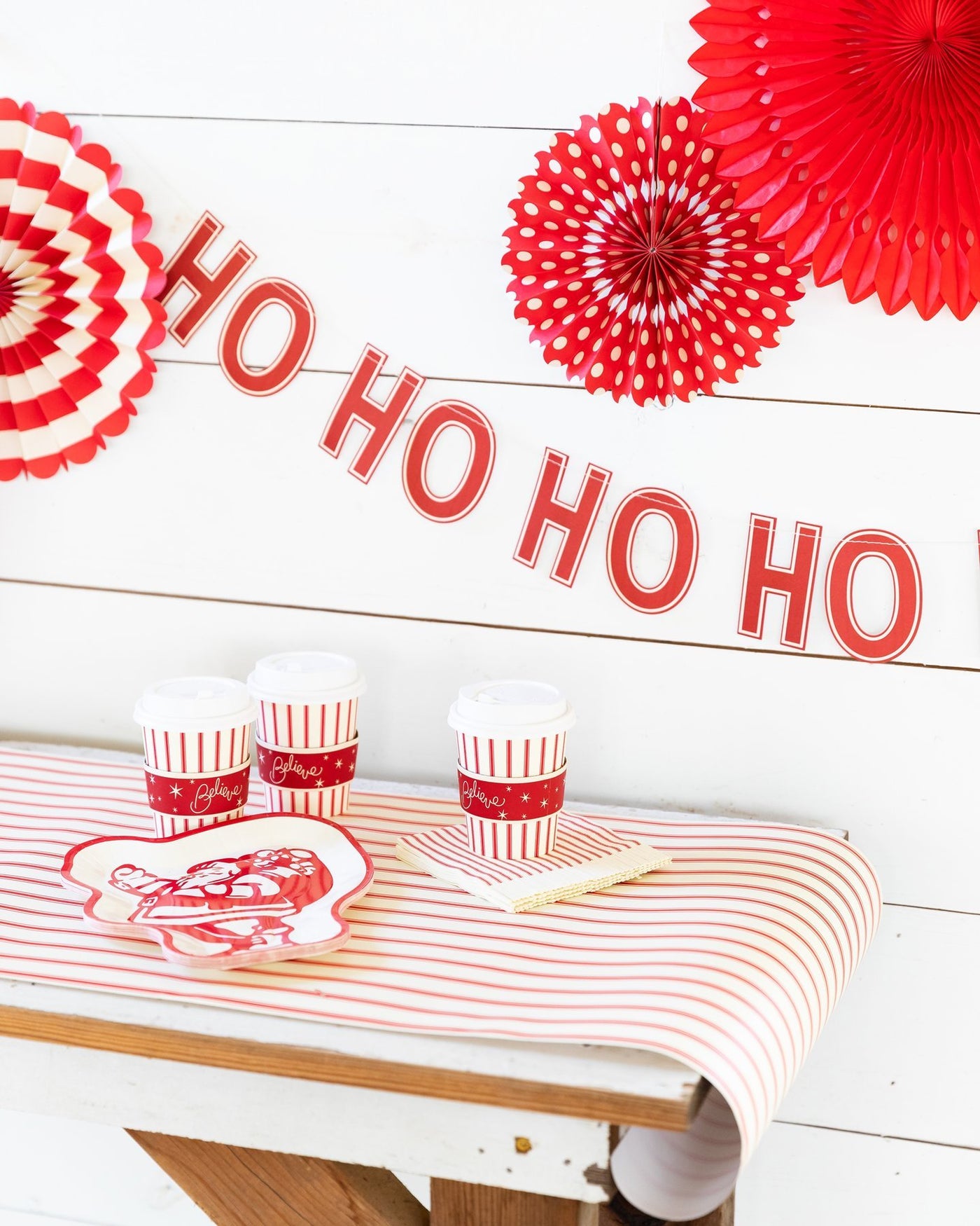 Believe red and white table runner on table with festive holiday drinks and Ho Ho Ho banner