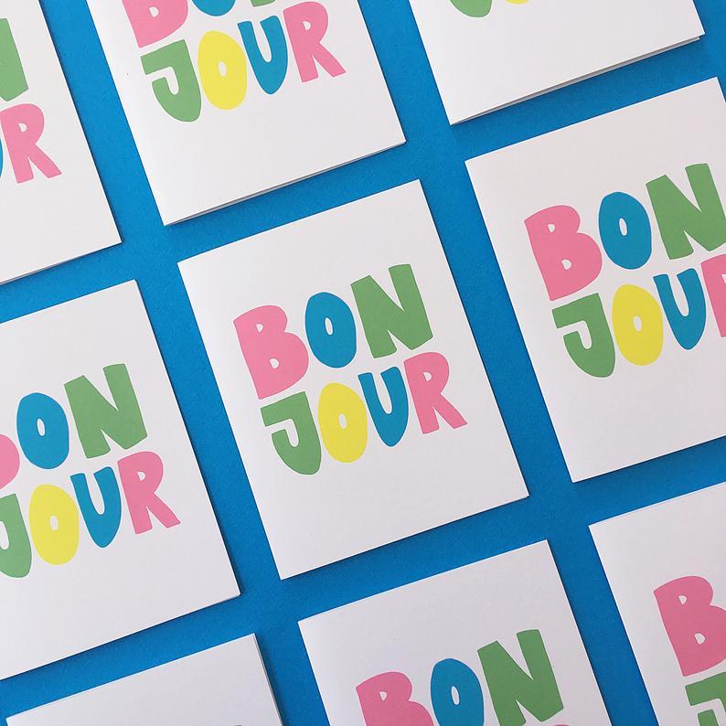 A set of bonjour greeting cards displayed over a blue background