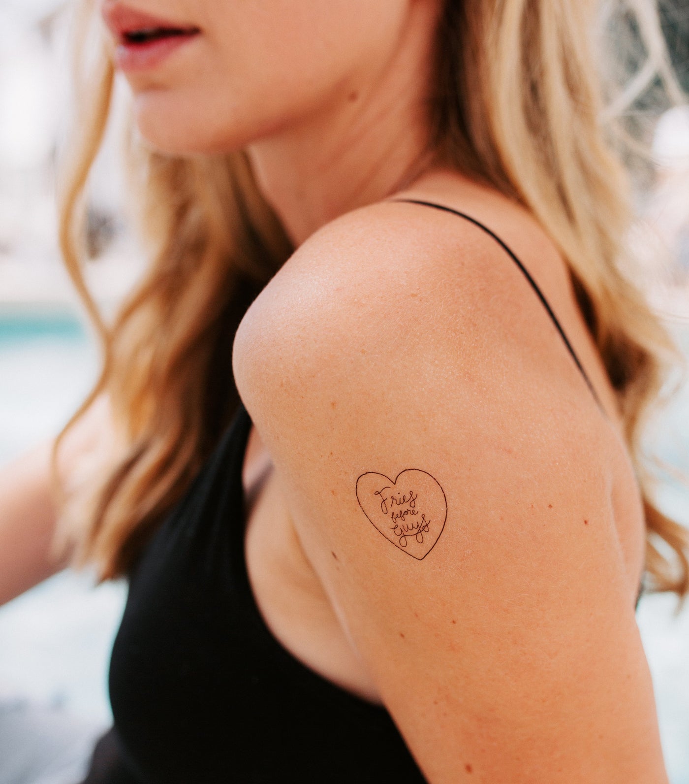 Girl gang tattoo pack - an image showing a temporary tattoo applied to a woman's arm with the text 'fries before guys' encircled by a heart