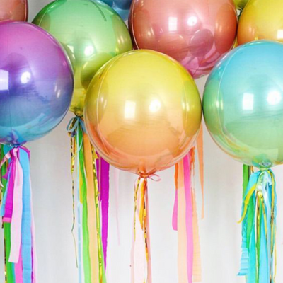 An assortment of large 16" spherical balloons in a variety of colors attached by ribbon