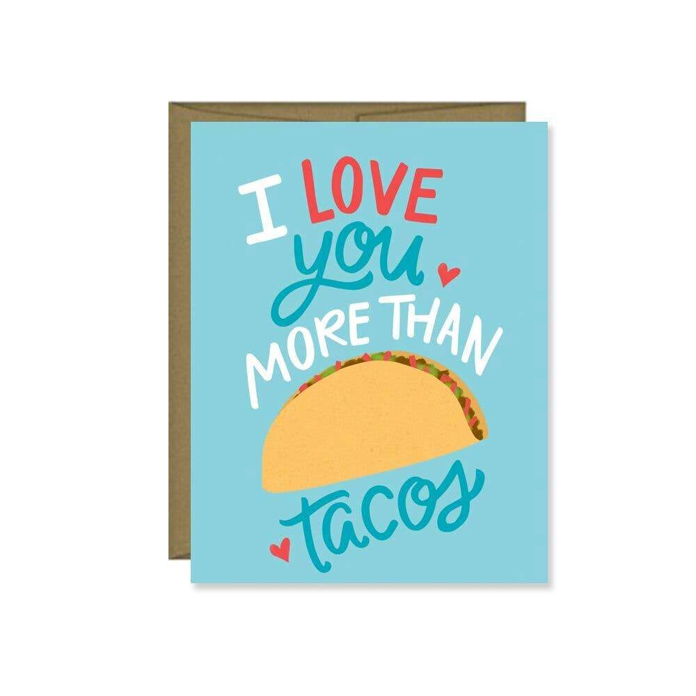 A silly card set on blue card stock with an image of a taco and the words 'I love you more than tacos' imprinted on the face with a few hearts