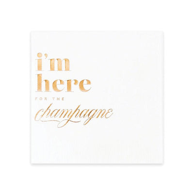 A white cocktail napkin with the words 'I'm here for the champagne' imprinted in rose gold foil