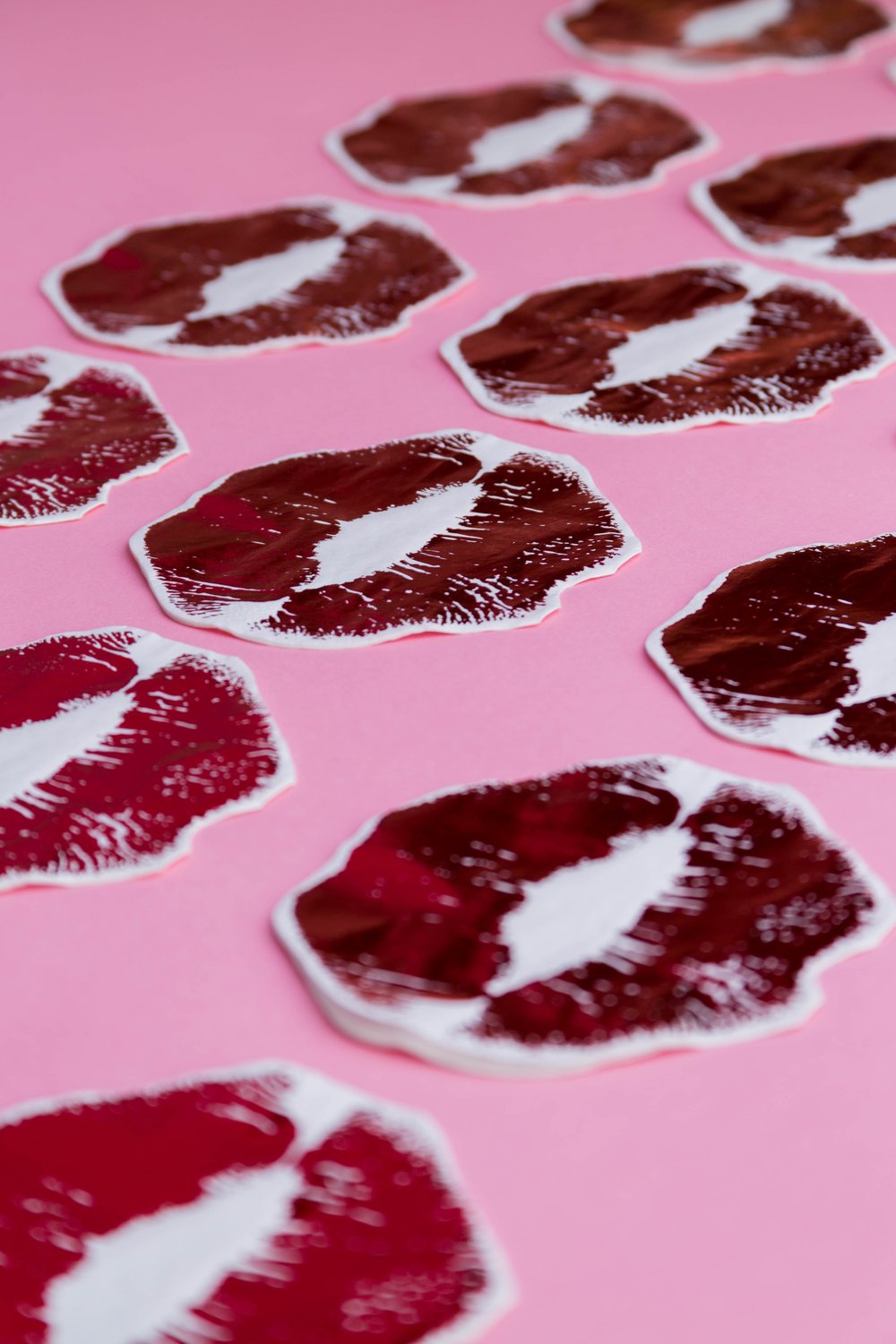 a set of kiss napkins arranged on a pink background