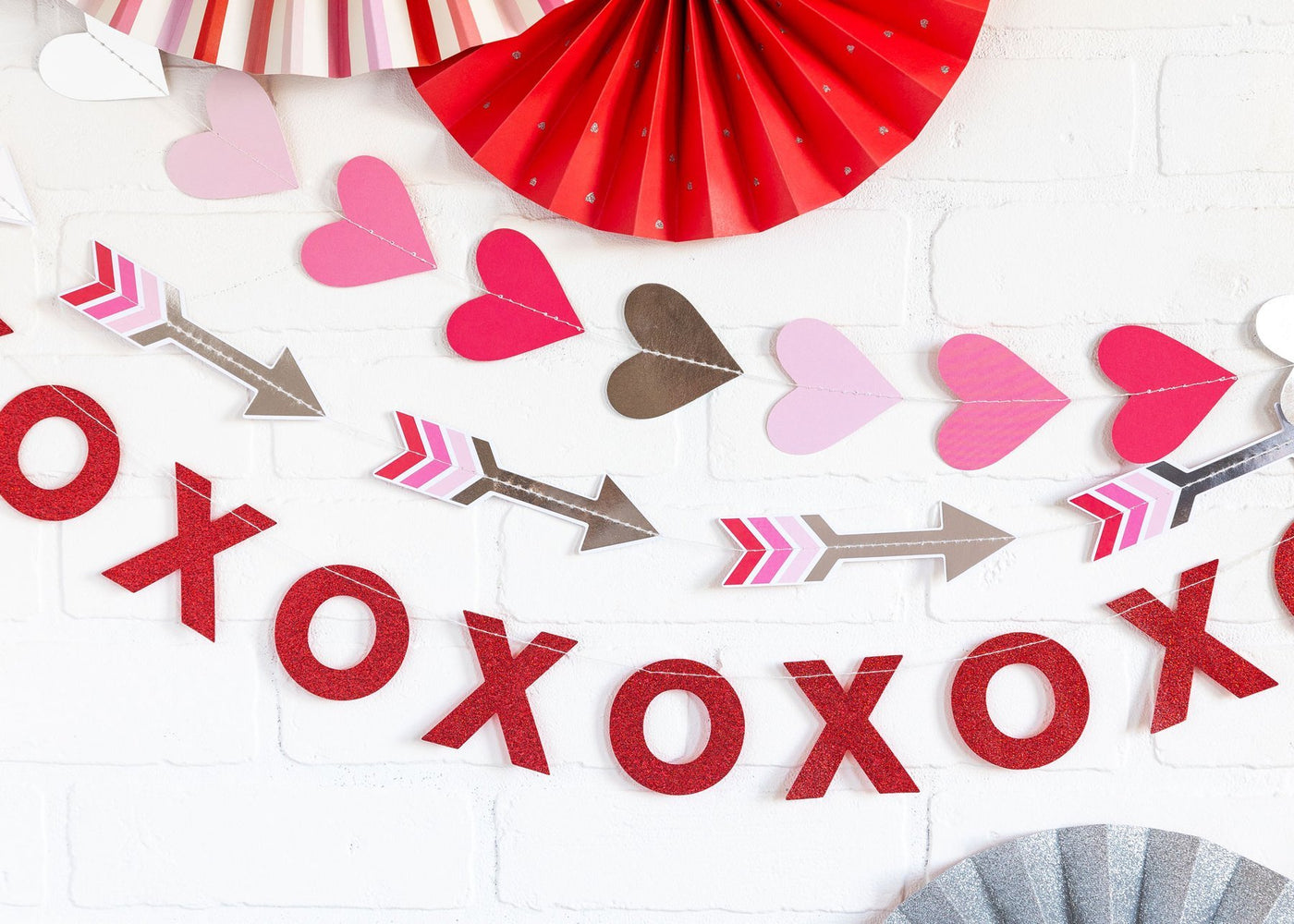 Each valentines day wall banner set hung and displayed in front of a white wall with other valentine's day decor