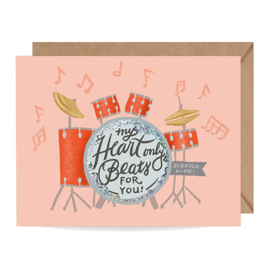 A valentine's day greeting card featuring a drum set with an area on the bass drum that is able to be scratched off to reveal a special valentine's day message